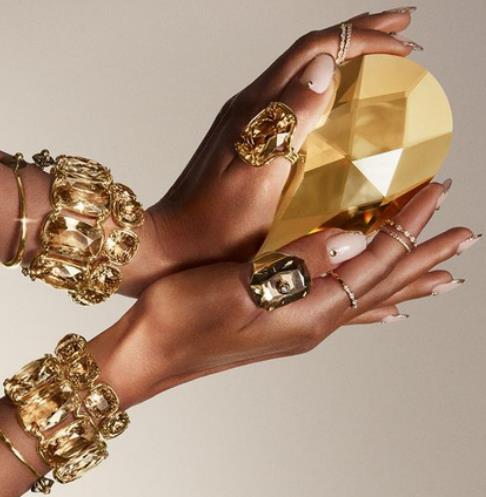 Hands wearing gold bracelets and rings